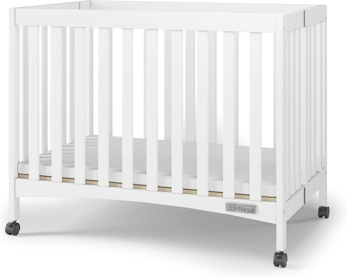 Child Craft London Mini Compact Folding Portable Crib with 2” Crib Mattress and 2 Easy Roll Locking Wheels, Durable Pine Wood Construction (Matte White)